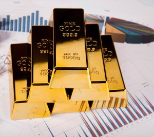 Stack of gold bars with asset allocation chart in background.