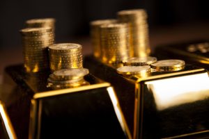 Stacked gold bars and coins for gold IRA rollovers.